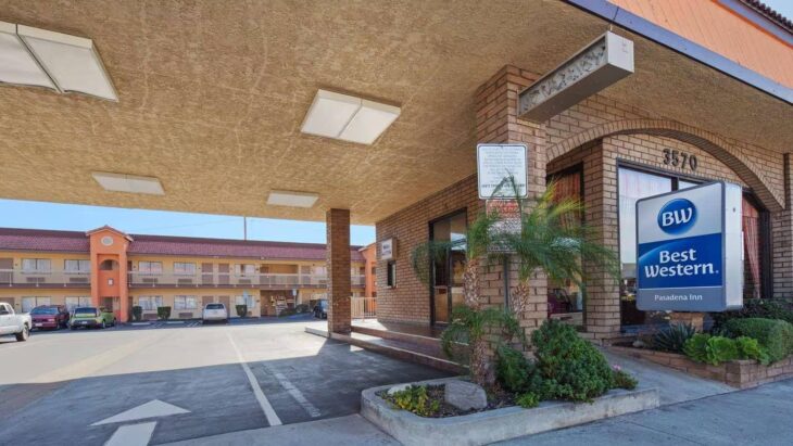 The covered main entrance of the Best Western Pasadena Inn, with a brick facade and the hotel sign visible.