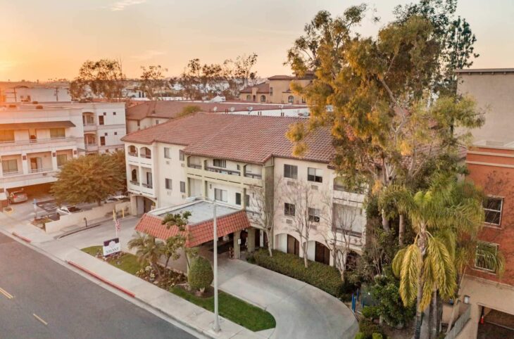 The Savant of Alhambra building at sunset with a red-tiled roof and covered entrance.