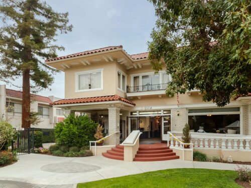Cozy Silverado The Huntington memory care home with inviting entrance, lush garden, and red-tiled roof.
