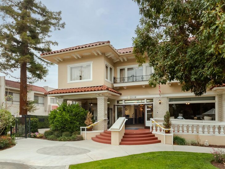 Cozy Silverado The Huntington memory care home with inviting entrance, lush garden, and red-tiled roof.