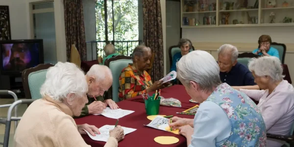 Elderly residents coloring and socializing in the activity room at Jasmin Terrace at El Molino, Pasadena