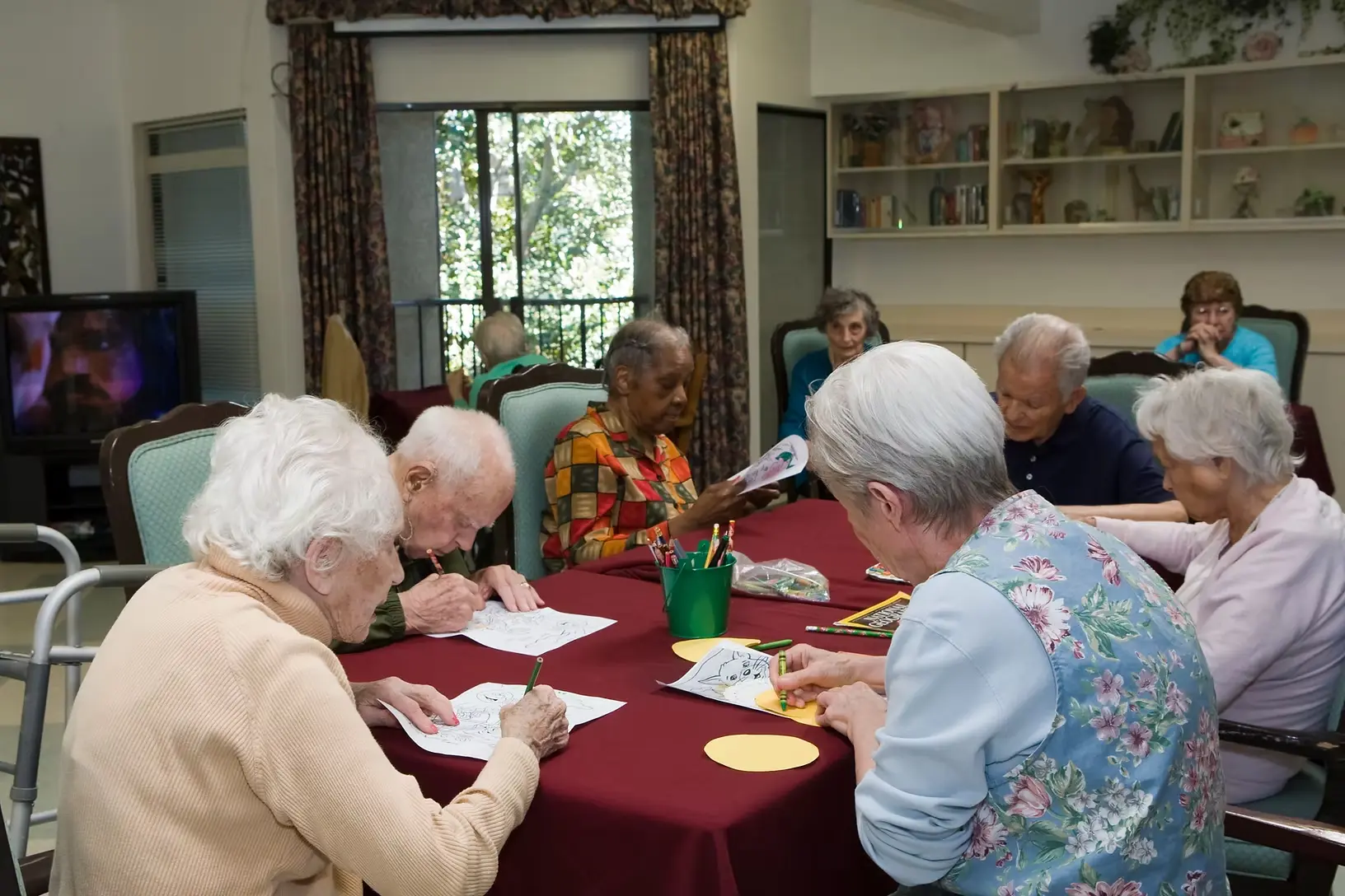 Elderly residents coloring and socializing in the activity room at Jasmin Terrace at El Molino, Pasadena