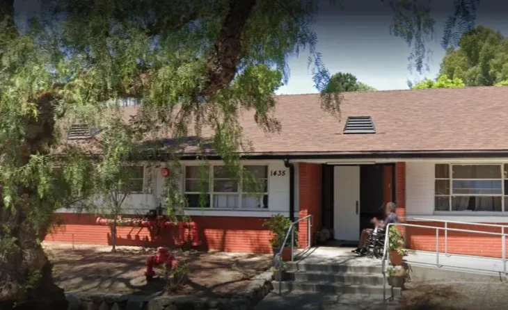 Exterior view of Garfield Terrace LLC assisted living facility with entrance ramp and resident outside
