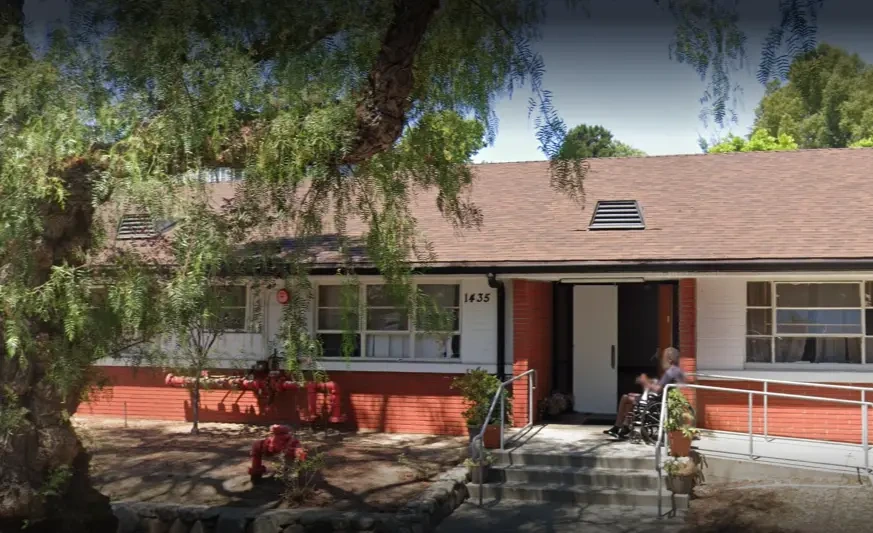Exterior view of Garfield Terrace LLC assisted living facility with entrance ramp and resident outside