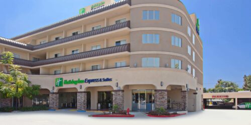 Holiday Inn Express Pasadena exterior with four stories, balconies and green neon sign