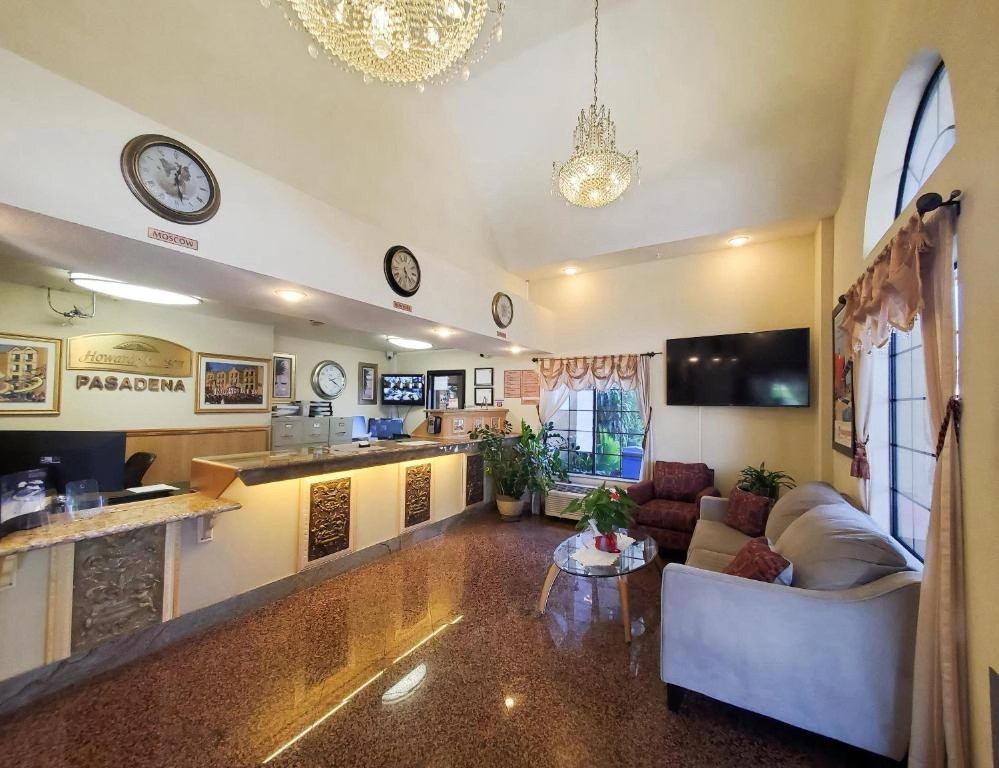 Elegant hotel lobby with chandeliers, reception desk, and seating area at Howard Johnson Pasadena