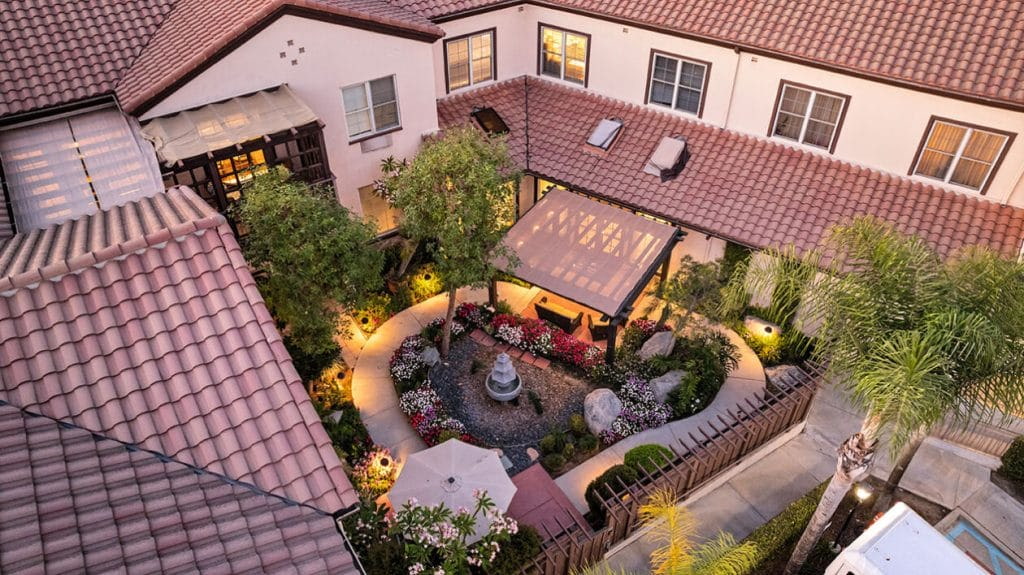 Courtyard garden with fountain and shaded seating at Ivy Park San Marino