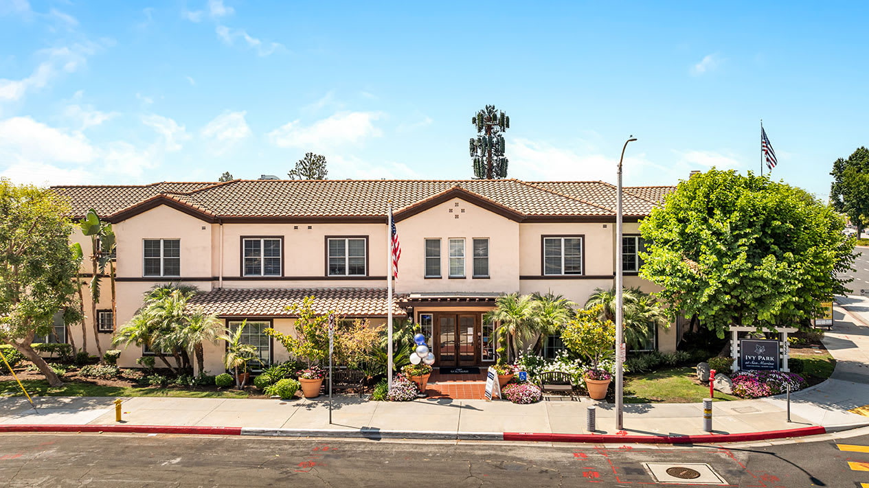 Front view of Ivy Park San Marino assisted living residence with entrance and palm trees