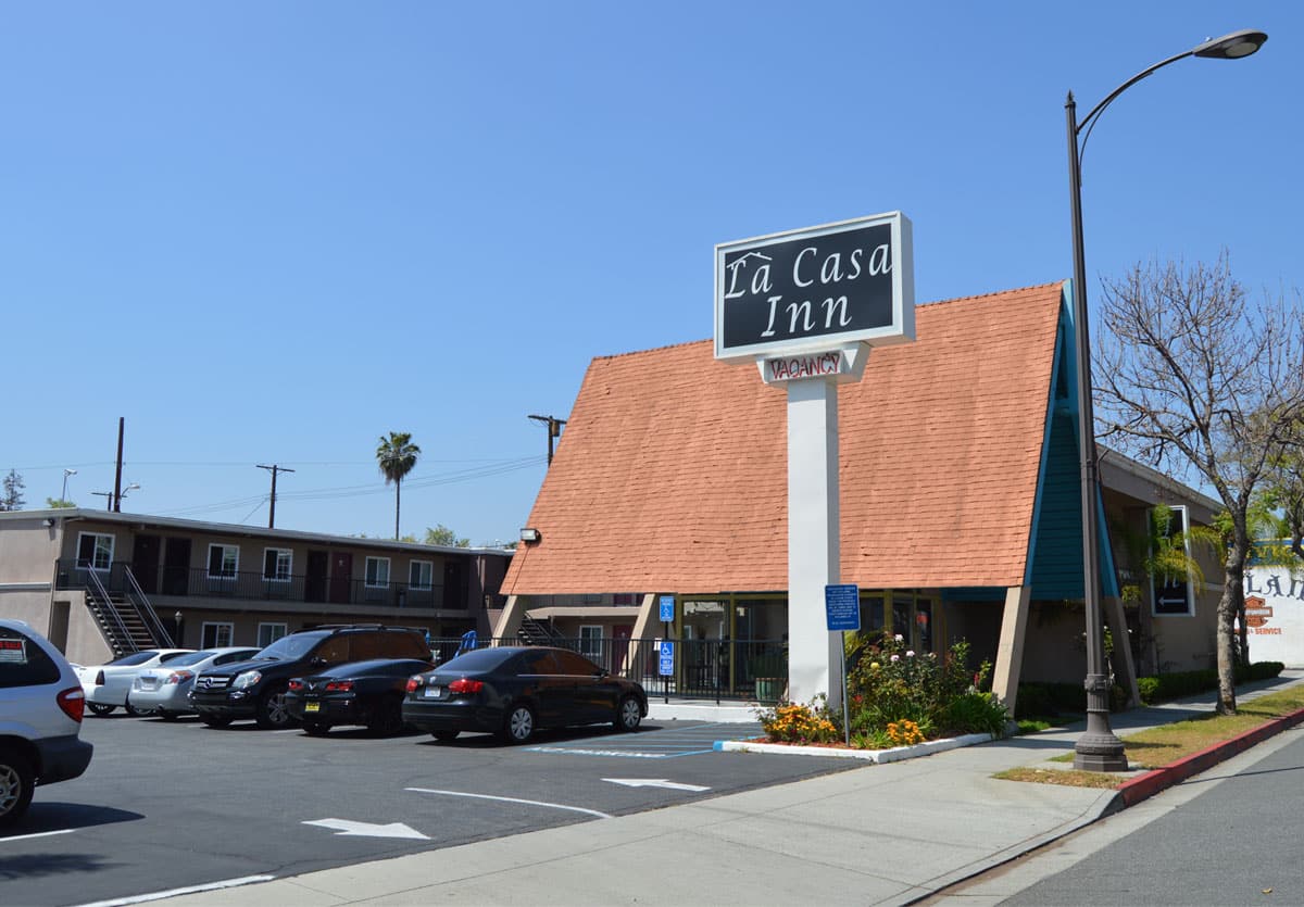 Exterior view of La Casa Inn with parking lot and main entrance