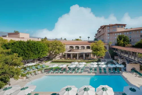 Outdoor pool at The Langham Huntington Pasadena surrounded by lounge chairs and umbrellas
