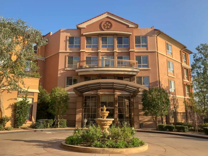Exterior view of MorningStar Senior Living Pasadena with fountain and landscaped entrance
