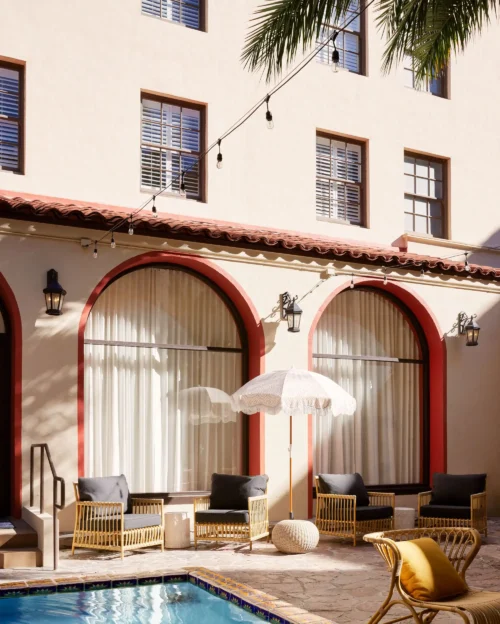Courtyard poolside seating area at Pasadena Hotel with umbrellas and lounge chairs