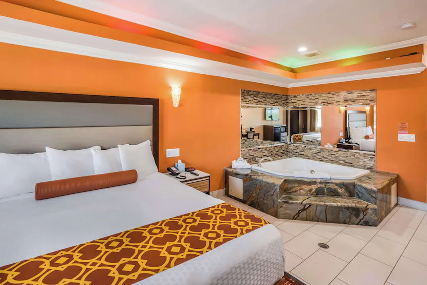 Guest room at Rodeway Inn Pasadena with spa tub and orange accent wall