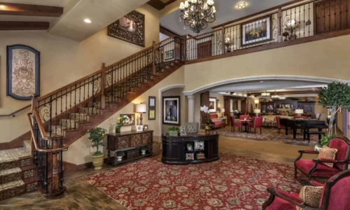 Grand lobby with staircase, chandelier, and lounge area at The Kensington Sierra Madre