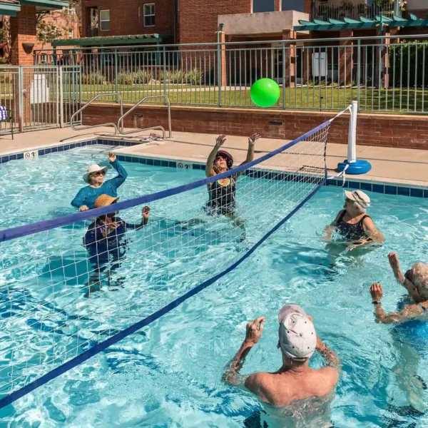 Group of residents playing water volleyball in pool at Royal Oaks Duarte CA