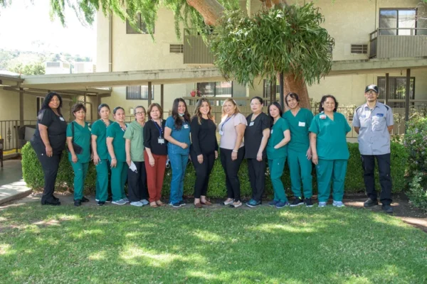 Solheim Senior Community care team standing together on the lawn in front of the building