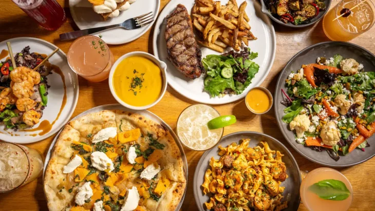 true-food-kitchen-seasonal-menu-items-flatlay A variety of True Food Kitchen seasonal menu items including butternut squash pizza, grass-fed steak, shrimp, fresh salads, and organic cocktails.